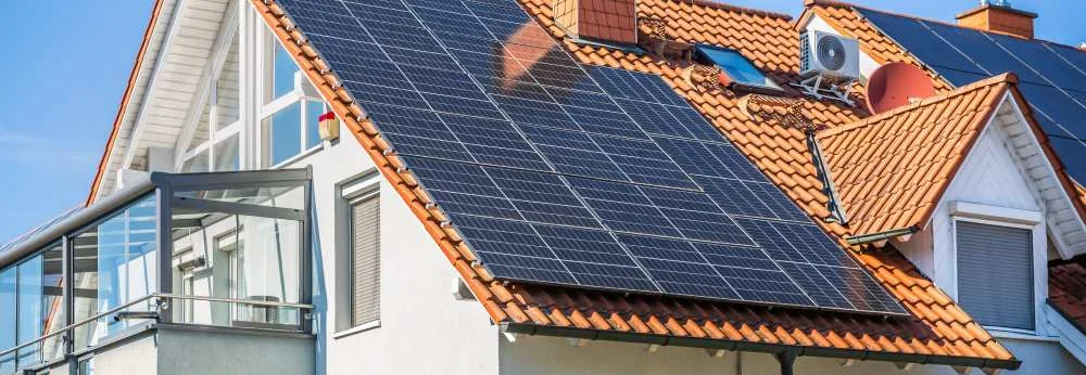 Solarmodule auf dem Dach eines modernen Hauses.